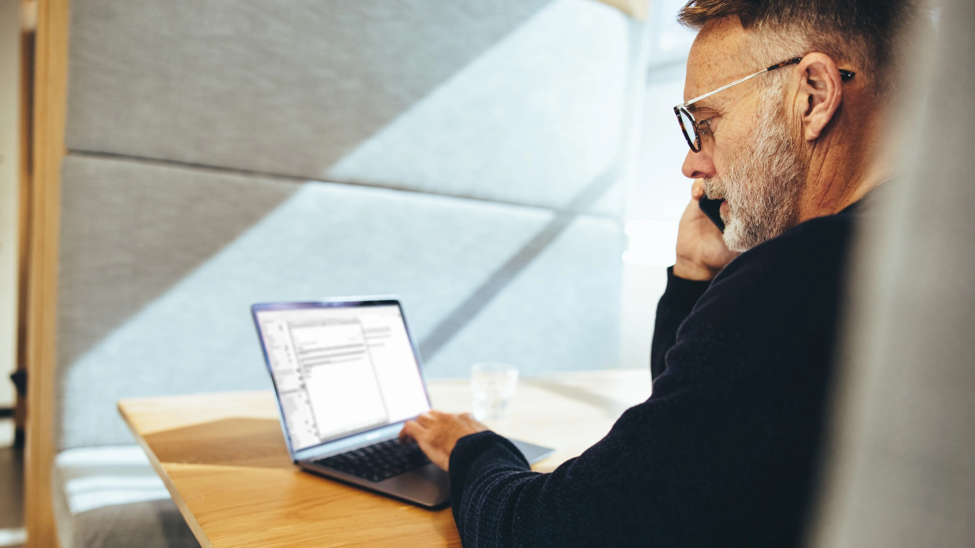 Man reading document on his laptop
